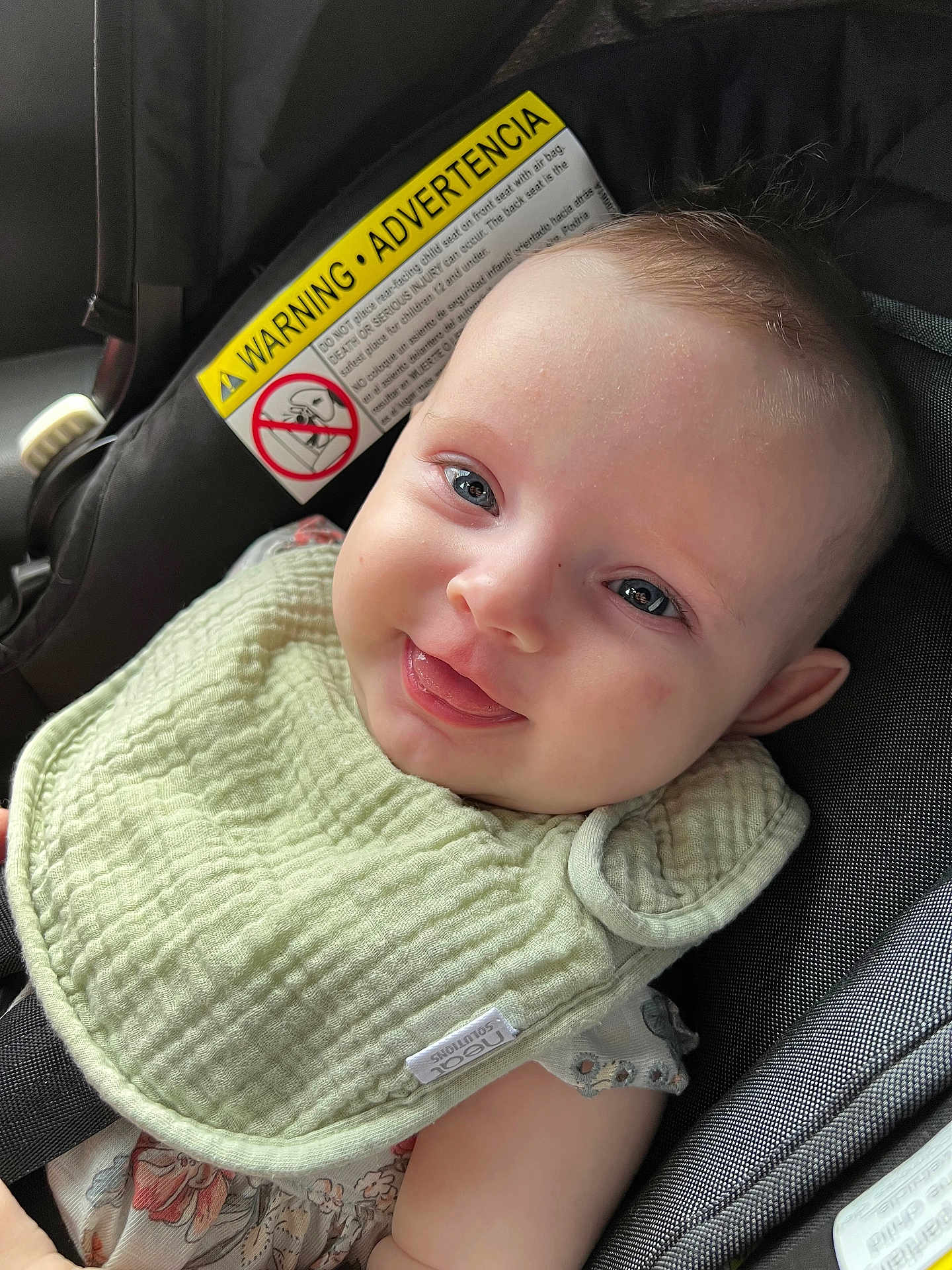 Oakleigh joined the competition — help win amazing prizes! baby, child, smile, tongue, car_seat, bib, clothing, face, infant, warning_label, seatbelt, cute, happy, portrait, person, young_child, indoor, head, skin, baby_fashion
