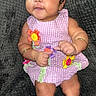 Gianni joined the competition — help win amazing prizes! baby, child, infant, dress, pink_dress, flower_decorations, bracelets, curly_hair, smiling, sitting, textured_blanket, dark_background, cute, looking_up, skin, arms, legs, portrait, indoors, person