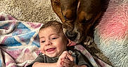 Abbey Girl joined the competition — help win amazing prizes! baby, baby_clothing, blanket, brown_dog, carpet, cuddling, dog, family, friendship, happy, home, indoor, infant, lying_down, pet, pink_pillow, portrait, short_hair, smiling, text_on_shirt