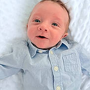 Maël participe au concours pour gagner de l'argent avec cette photo : baby, infant, child, blue_shirt, face, eyes, smile, lying_down, blanket, white_background, cute, portrait, soft_light, newborn, buttoned_shirt, head, skin, happy, young, person