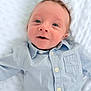 baby, infant, child, blue_shirt, face, eyes, smile, lying_down, blanket, white_background, cute, portrait, soft_light, newborn, buttoned_shirt, head, skin, happy, young, person