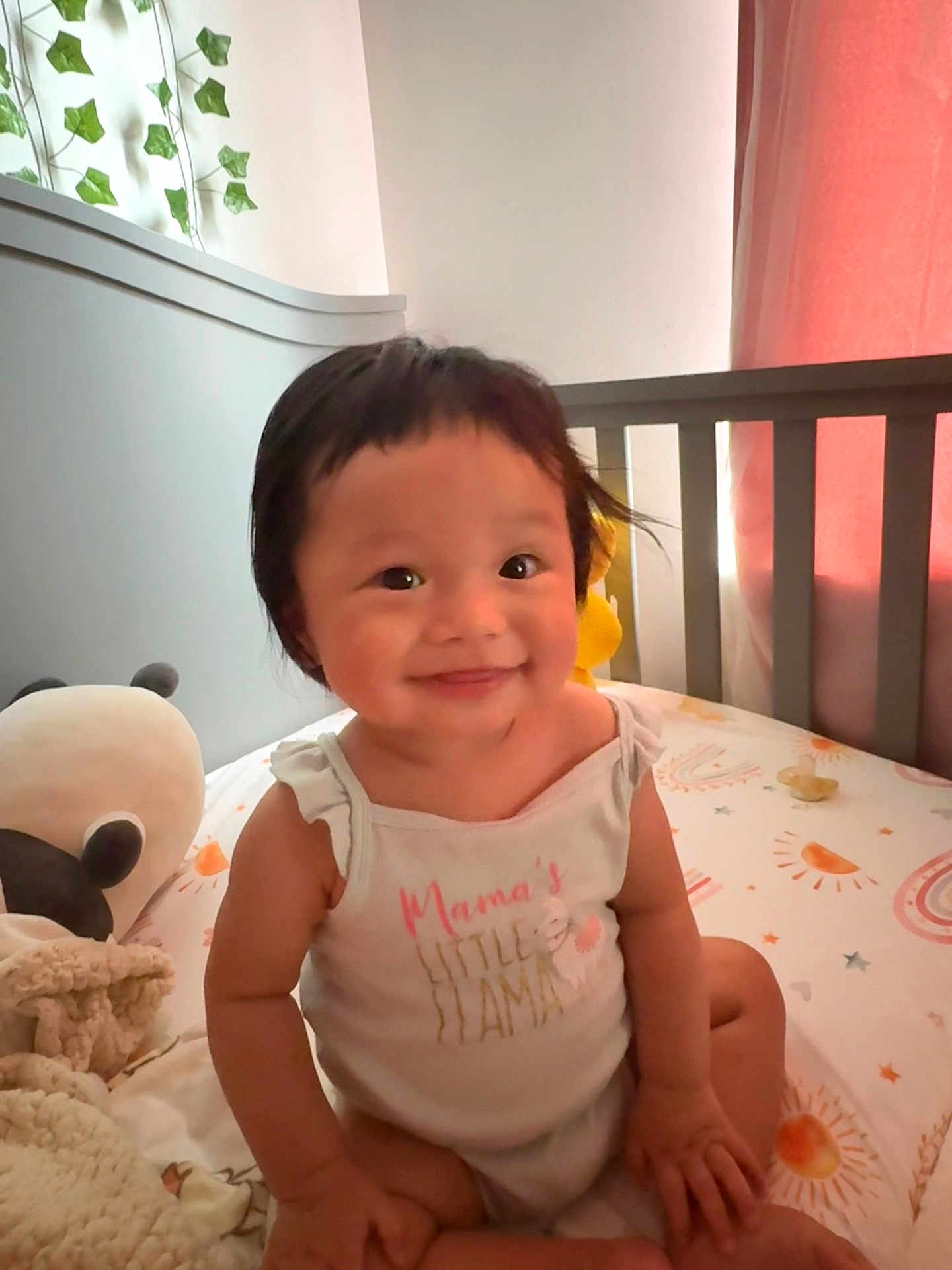 Lydia joined the competition — help win amazing prizes! baby, child, smile, crib, onesie, plush_toy, panda, blanket, nursery, curtain, sunlight, bed, cute, infant, sitting, happy, indoor, person, face, clothing