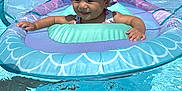 Lydia is registered to the contest to win money with this photo: baby, child, pool, water, float, inflatable, hat, bow, sunshade, swimming, summer, outdoor, smiling, happy, vacation, recreation, blue, sky, sunlight, fun