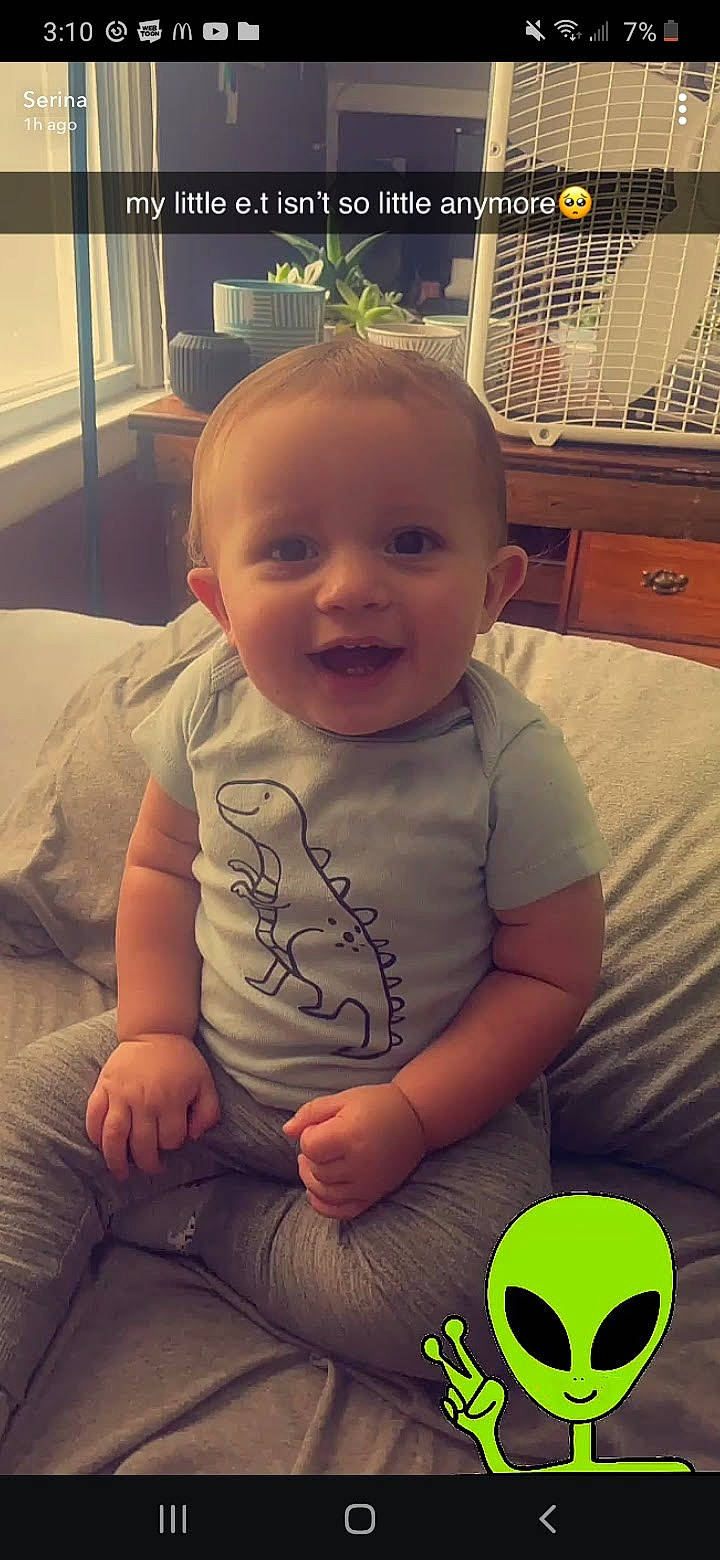 Eden is registered to the contest to win money with this photo: arm, black, cheek, chin, eye, finger, green, happy, head, houseplant, human_body, light, mouth, nose, organ, person, photograph, plant, skin, smile