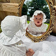 Sienna joined the competition — help win amazing prizes! baby, child, mirror, reflection, white_clothing, bonnet, outdoor, grass, trees, sky, wooden_fence, golden_frame, curious, crawling, blanket, portrait, sunlight, cute, face, nature