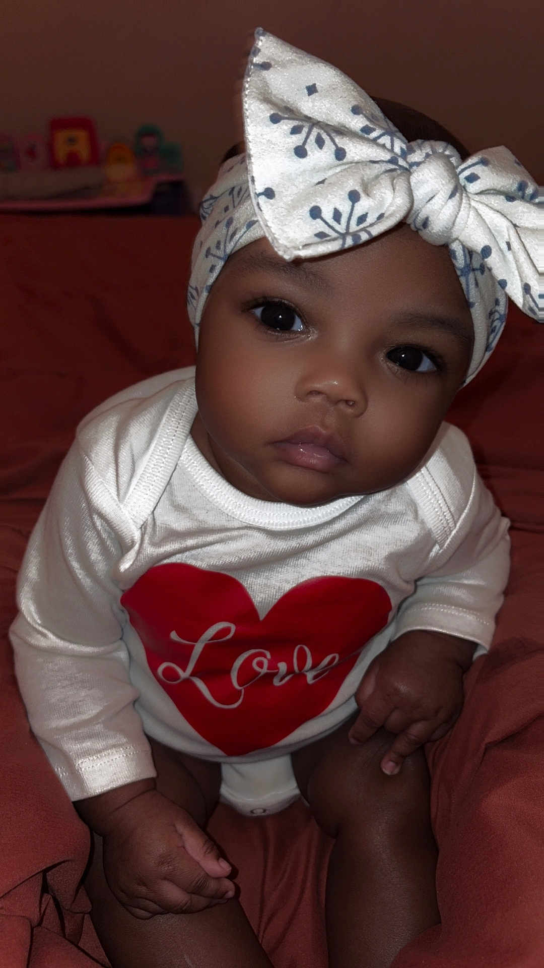 Fayonah joined the competition — help win amazing prizes! baby, infant, child, headband, bow, onesie, love, heart, clothing, skin, hand, face, eyes, sitting, blanket, indoors, cute, portrait, soft, expression