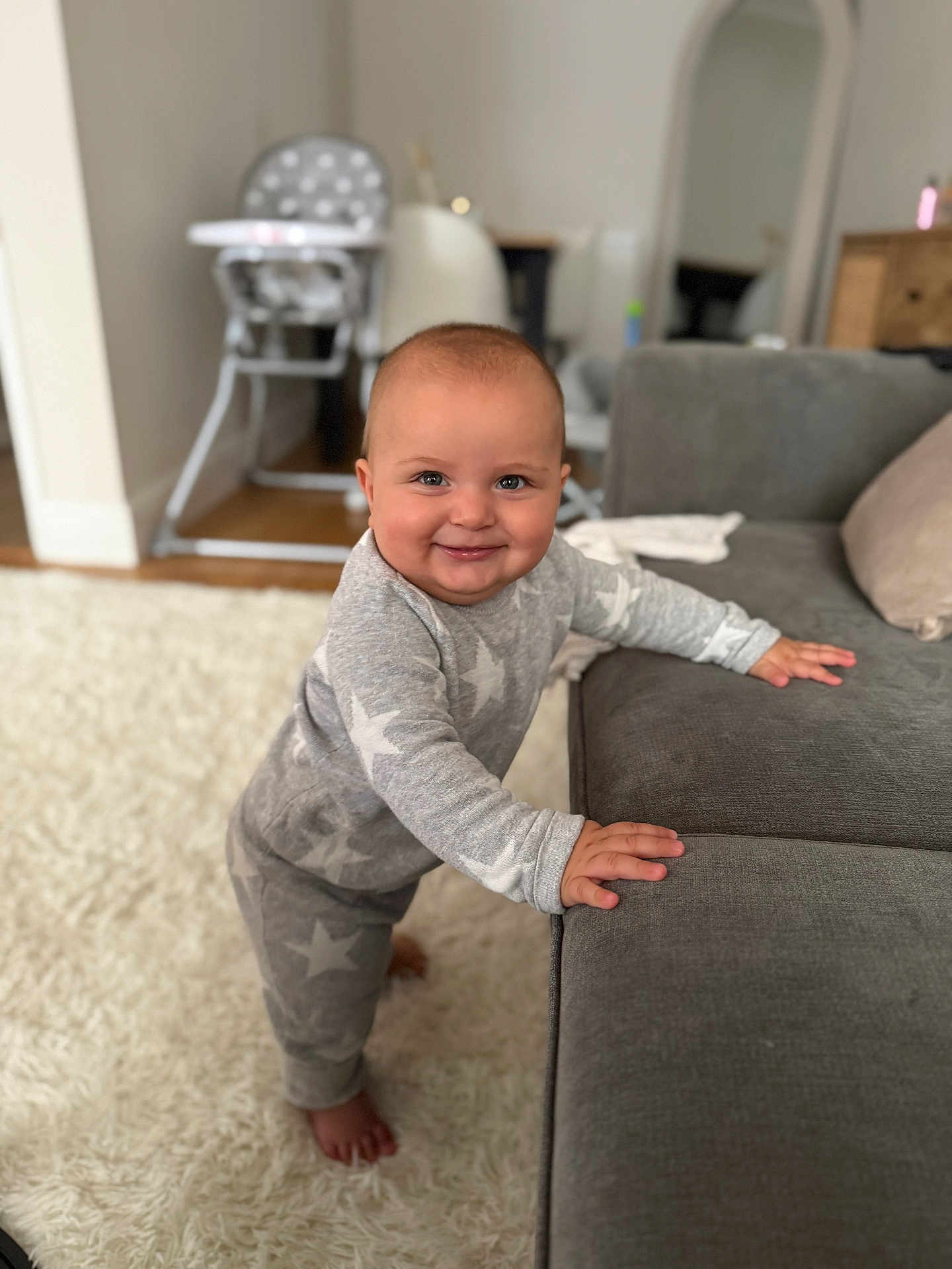 Rowen joined the competition — help win amazing prizes! baby, child, smile, pajamas, star_pattern, couch, carpet, indoor, furniture, person, standing, home, cute, happy, floor, hand, feet, head, face, room