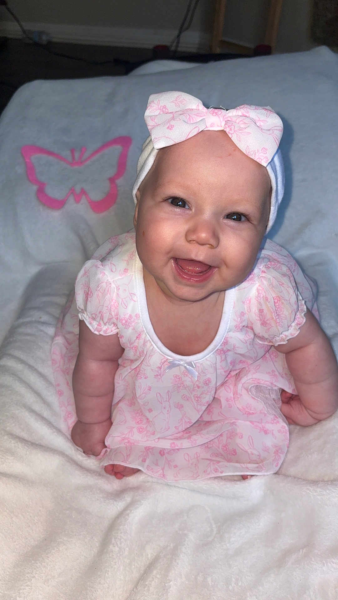 Lylah joined the competition — help win amazing prizes! baby, infant, child, smiling, bow, headband, pink_dress, floral_pattern, blanket, butterfly, chubby_cheeks, open_mouth, tooth, portrait, sitting, indoor, flash, plush, cute, happy