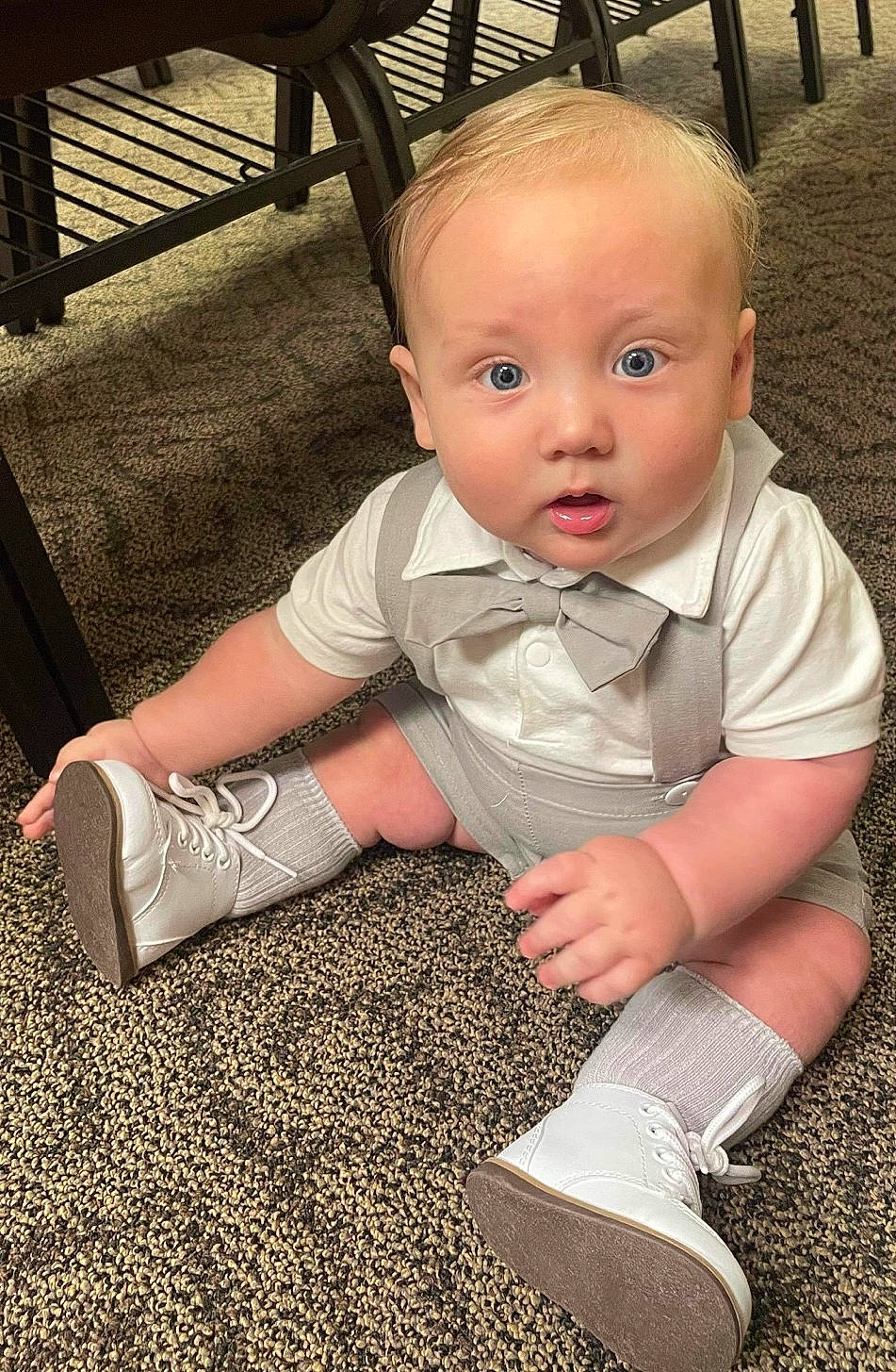 Liam is registered to the contest to win money with this photo: baby, baby_toddler_clothing, blond, chair, cheek, comfort, face, finger, floor, flooring, foot, fun, grass, hand, head, human_leg, iris, leg, person, surprise