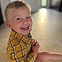 Nino a rejoint le concours — aidez-le/la à gagner de superbes lots ! child, smiling, indoor, yellow_shirt, plaid, happy, boy, toddler, sitting, face, portrait, blond_hair, young, cute, casual_clothing, cheerful, bright, playful, floor, background_blur