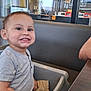 toddler, child, high_chair, smiling, food, indoor, restaurant, table, seat, casual, menu, reflection, window, shorts, shirt, person, happy, baby, cute, dining