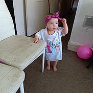 Kaïssy a rejoint le concours — aidez-le/la à gagner de superbes lots ! toddler, child, barefoot, headband, white_tshirt, cartoon_print, indoor, chair, floor, balloon, purple, hand, standing, carpet, door, wall, furniture, person, home, baby