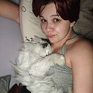 Loki is registered to the contest to win money with this photo: arm, bed, blanket, cat, close_up, cozy, cuddling, earring, hair, indoor, long_fur, person, pet, pillow, portrait, relaxed, selfie, skin, sleeping_cat, tank_top