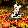 Dylan joined the competition — help win amazing prizes! baby, child, autumn, pumpkin, fall_leaves, hat, outdoor, smiling, nature, seasonal, cute, portrait, orange, yellow, green, black_and_white_clothing, wooden_chest, grass, festive, holiday