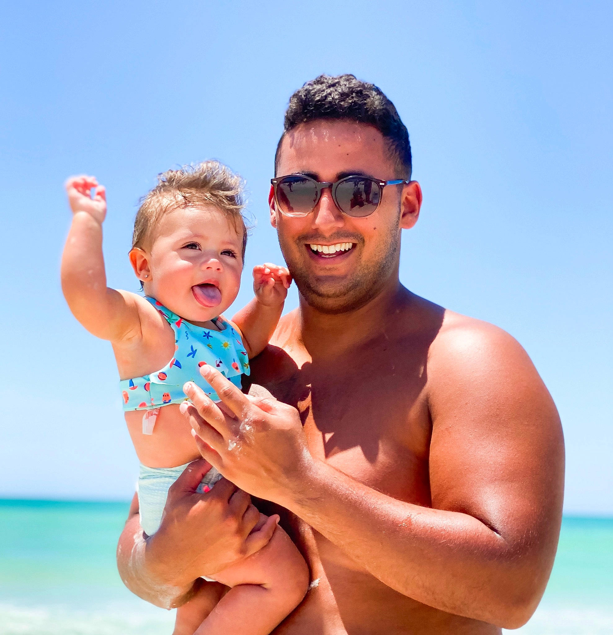 Ziah is registered to the contest to win money with this photo: arm, barechested, beach, child, fun, gesture, happy, holiday, joy, leisure, muscle, people_on_beach, person, smile, spring_break, summer, sun_tanning, toddler, vacation