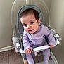 baby, child, high_chair, purple_onesie, sitting, indoor, floor, tile_floor, wall, footrest, safety_bar, grip, curious, smiling, person, young_child, earrings, transparent_chair, modern_furniture, home