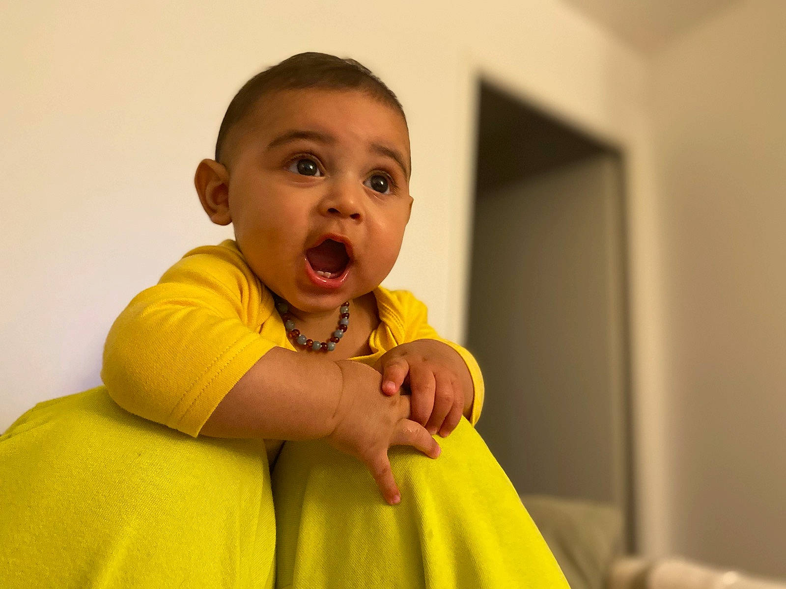 Maydan participe au concours pour gagner de l'argent avec cette photo : baby, baby_toddler_clothing, cheek, comfort, dress, flash_photography, flooring, fun, gesture, happy, human_body, iris, leisure, nose, person, room, shoulder, sitting, sleeve, surprise