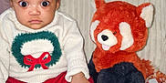 Caleigh is registered to the contest to win money with this photo: baby, child, plush_toy, red_panda, sweater, headband, bow, sitting, cozy, chair, indoor, cute, wide_eyes, sock, knitwear, holiday, soft_toy, person, portrait, expression