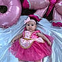 baby, infant, pink_dress, tutu, headband, balloons, outdoor, grass, blanket, socks, cute, portrait, child, celebration, party, face, lying_down, adorable, person, festive
