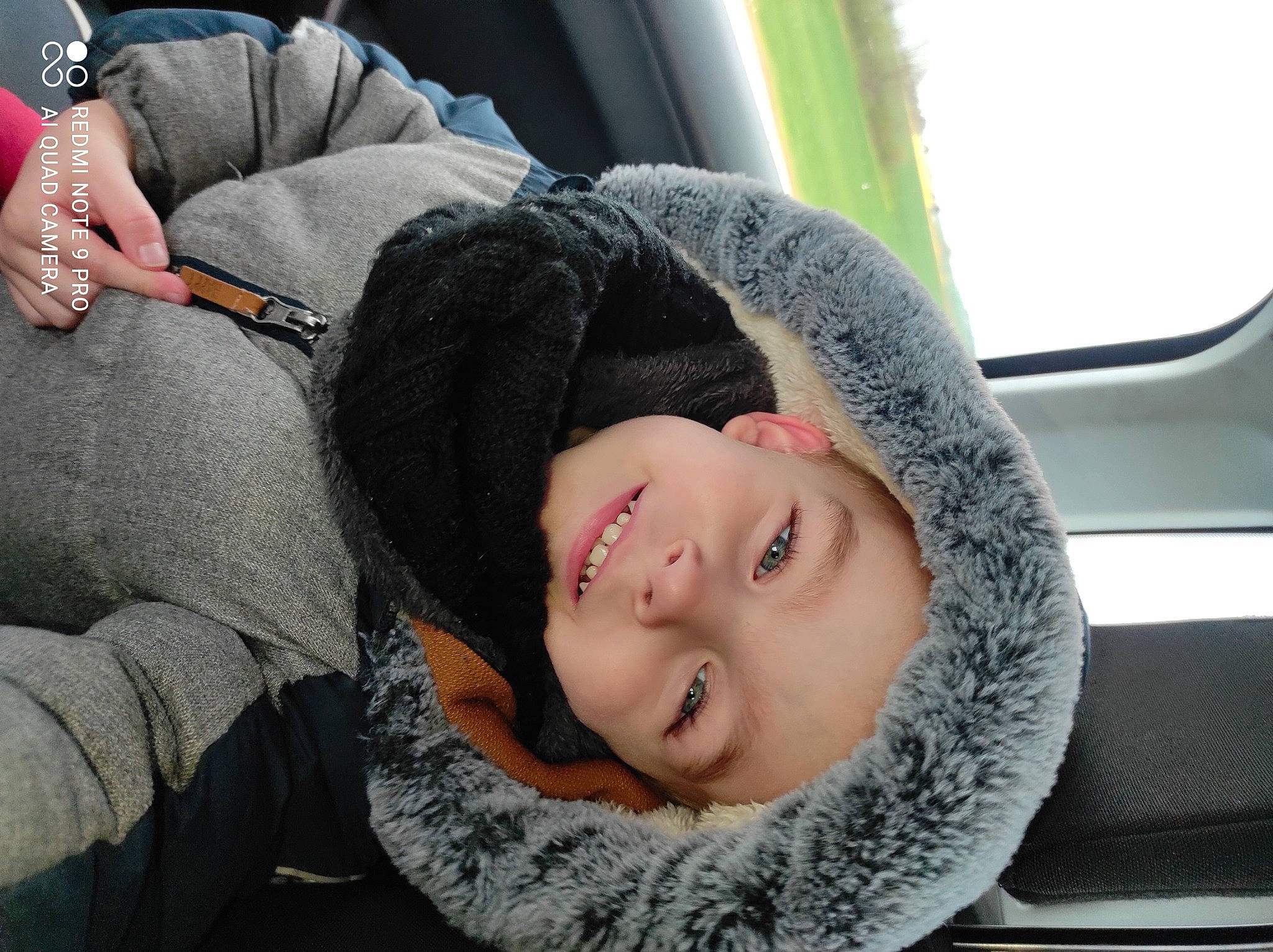 Valentin participe au concours pour gagner de l'argent avec cette photo : black_hair, blond, child, comfort, cool, family_car, fun, fur, gesture, grass, happy, headwear, human_leg, joy, lip, nose, person, sitting, skin, smile