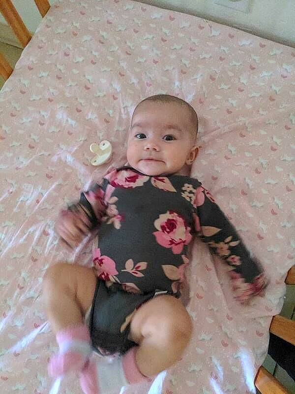 Amara is registered to the contest to win money with this photo: baby, baby_products, baby_toddler_clothing, cheek, child, chin, comfort, embellishment, eye, flooring, linens, pattern, person, pink, sitting, skin, sleeve, sock, textile, thigh