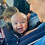 baby, smiling, blue_eyes, baby_carrier, denim, adult, person, happy, close_up, face, child, holding, casual_clothing, indoor, people, parent, family, joy, cute, love
