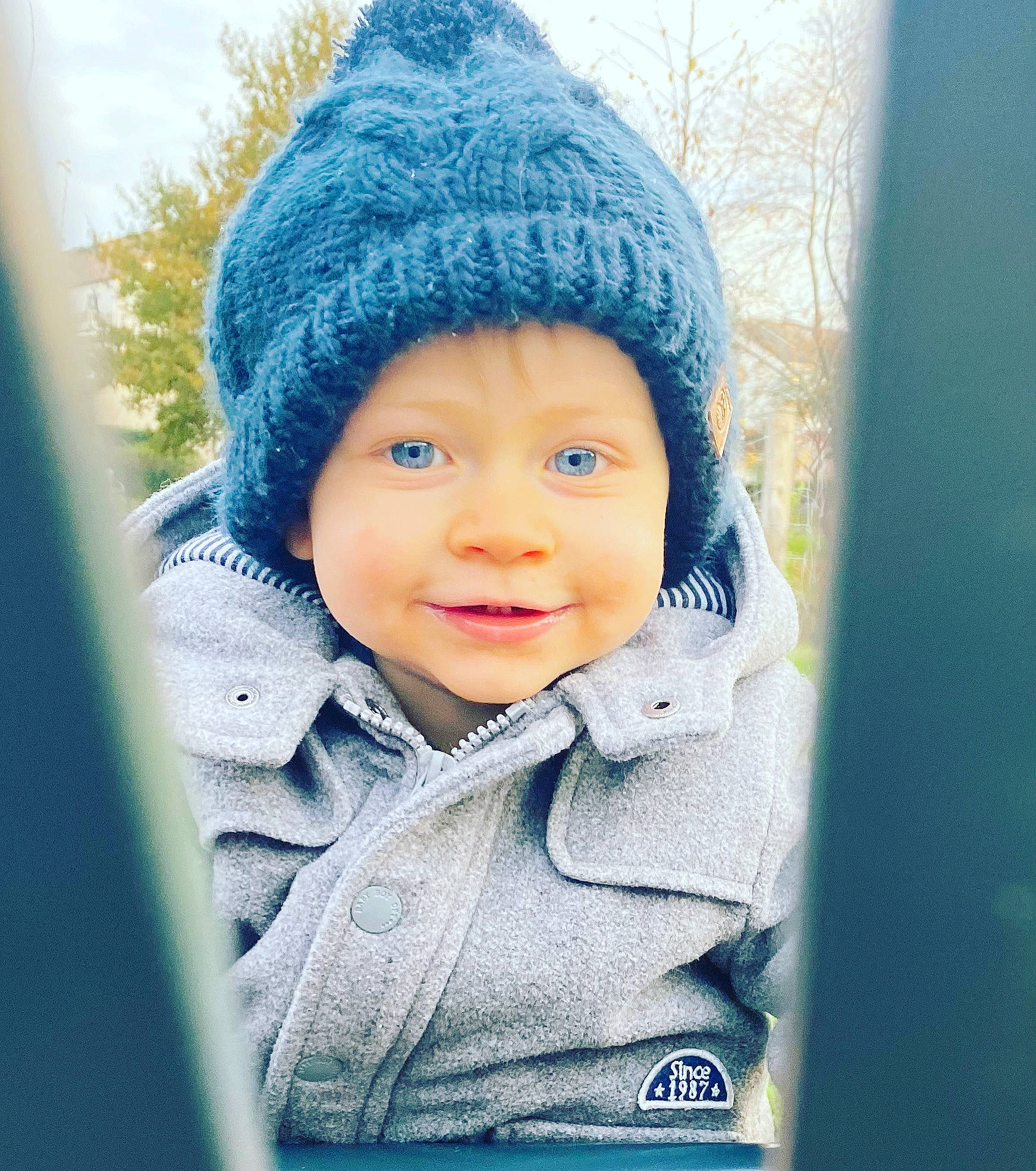 Ethan a rejoint le concours — aidez-le/la à gagner de superbes lots ! baby, baby_toddler_clothing, cap, child, electric_blue, face, fashion_accessory, fun, grass, happy, headwear, hood, knit_cap, outerwear, person, sleeve, smile, toddler, tree, winter