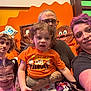 Odin joined the competition — help win amazing prizes! family, child, toddler, adult, glasses, tattoo, selfie, orange_shirt, curly_hair, pigtails, purple_hair, smile, indoor, colorful_background, candy_decoration, group, portrait, casual_clothing, happy, people
