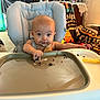 baby, high_chair, messy, chocolate, cake, crumbs, face, hands, indoor, living_room, furniture, blanket, person, child, food, snack, cute, infant, seat, expression