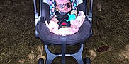 Sadie is registered to the contest to win money with this photo: baby, car_seat, sunglasses, pink_bow, infant, outdoor, stone_wall, child, toy, footwear, seatbelt, sunlight, shadow, ground, wheels, stroller, cute, fashion, accessory, relaxing