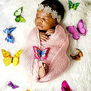 Alba joined the competition — help win amazing prizes! baby, sleeping, wrapped, pink_blanket, headband, flowers, butterflies, colorful, soft_texture, white_background, newborn, peaceful, hands, feet, portrait, infant, cozy, cute, decorative, lying_down