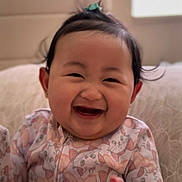 Amber joined the competition — help win amazing prizes! baby, child, smiling, happy, onesie, cute, indoor, portrait, face, hair, topknot, pillow, cozy, infant, clothing, patterned, cute_expression, young_child, sitting, joyful