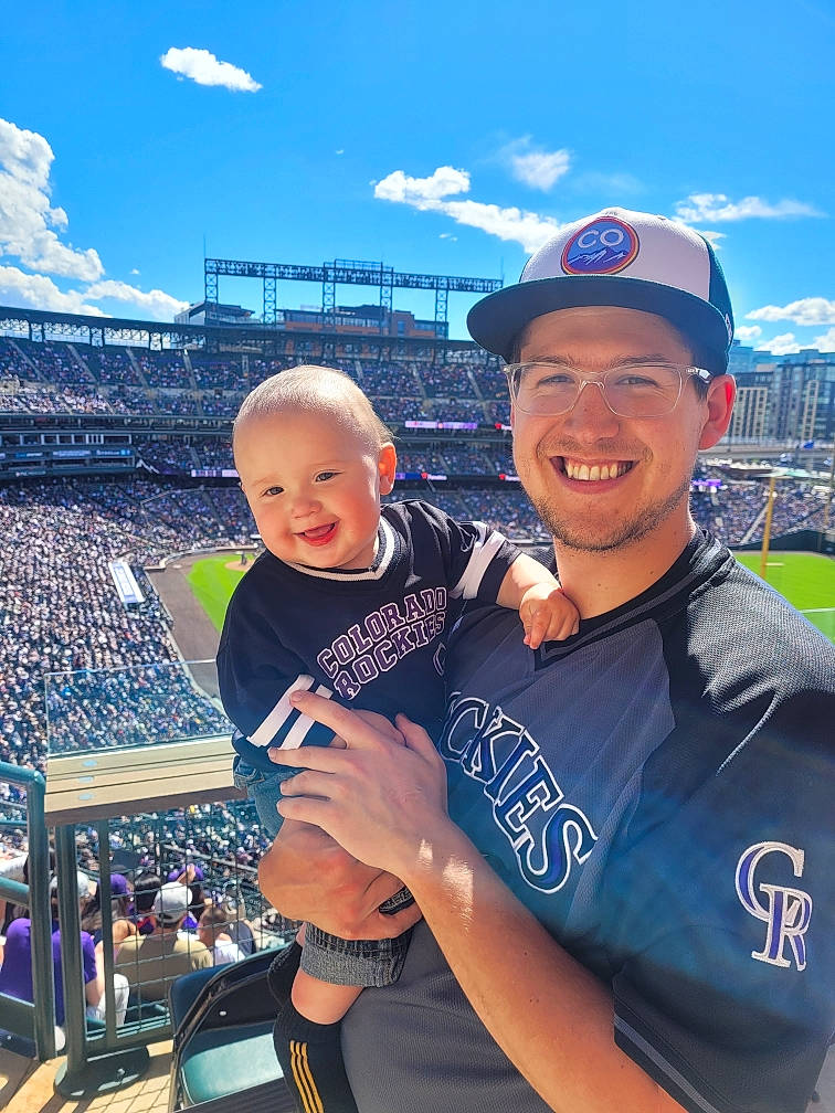 Darian is registered to the contest to win money with this photo: baseball_cap, blue, cap, cloud, competition_event, cool, electric_blue, fan, gesture, happy, headwear, joy, leisure, mountainous_landforms, muscle, person, player, sky, smile, sports