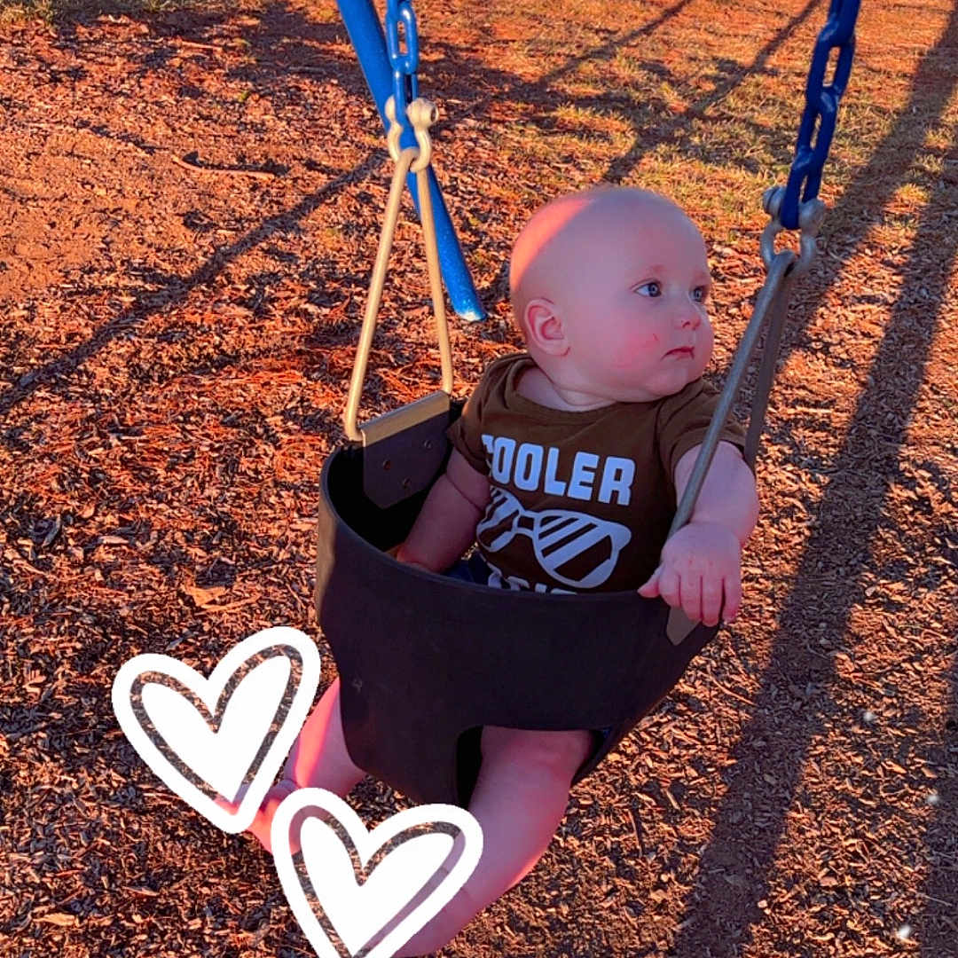 Beckham is registered to the contest to win money with this photo: baby, clothing, face, footwear, grass, head, nature, outdoorplayarea, outdoors, park, person, photography, plant, playarea, portrait, shoe, sitting, soil, toy, tree