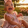 baby, blanket, child, dress, floral_dress, flowers, garden, golden_hour, grass, happy, infant, lake, laughing, outdoor, pink_bow, portrait, sitting, smiling, sunset, water