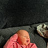 Briella joined the competition — help win amazing prizes! newborn, baby, infant, pink_sweater, striped_clothing, blanket, cozy, resting, cute, sleepwear, indoors, soft_texture, portrait, small_hands, face, head, person, child, lying_down, curious