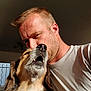 man, dog, face, close_up, indoor, natural_light, affection, pet, human, animal, companion, love, casual_clothing, short_hair, beard, smiling_dog, nose, whiskers, friendship, portrait