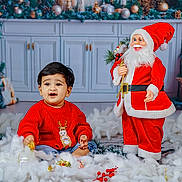 Noah joined the competition — help win amazing prizes! baby, child, red_sweater, reindeer, christmas, holiday, decorations, santa_claus, toys, gifts, indoor, festive, smiling, cute, winter, celebration, face, person, holiday_decor, seasonal