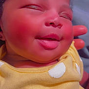 Nevaeh joined the competition — help win amazing prizes! baby, infant, child, sleeping, face, portrait, close_up, cheeks, tongue, smile, yellow_outfit, polka_dots, clothing, curly_hair, indoor, hand, cuddle, adorable, photography, happy