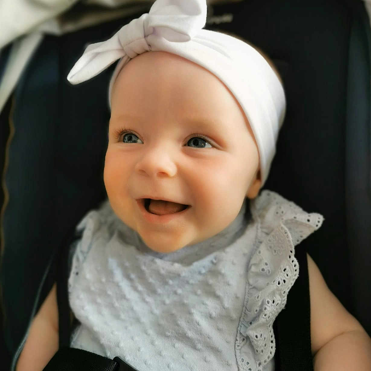 Ava joined the competition — help win amazing prizes! adorable, baby, bow, car_seat, child, clothing, cute, dress, eyes, face, happy, headband, infant, portrait, ruffles, seatbelt, skin, smile, straps, young