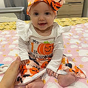 Alice participe au concours pour gagner de l'argent avec cette photo : baby, bedroom, blanket, child, clothing, costume, cute, decor, face, foot, furniture, halloween, hand, headband, indoors, person, pumpkin, sitting, smile, toy