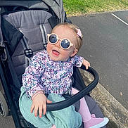 Alice participe au concours pour gagner de l'argent avec cette photo : accessory, baby, blanket, casual_wear, child, cute, floral_clothing, grass, happy, outdoor, park, pavement, person, pink_shoes, playful, smiling, stroller, sunglasses, sunny_day, toddler