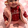 Alice participe au concours pour gagner de l'argent avec cette photo : baby, blonde_hair, blue_eyes, child, chubby_cheeks, closeup, cute, hello_sweater, indoor, legs, pink_background, pink_jacket, portrait, red_sweater, sitting, small_hands, smiling, socks, toddler, warm_clothing