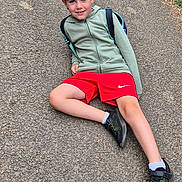 Enzo participe au concours pour gagner de l'argent avec cette photo : backward_cap, boy, cap, casual, child, daytime, gravel, greenery, hoodie, nature, outdoor, path, person, posing, recreation, red_shorts, relaxed, smiling, sneakers, young