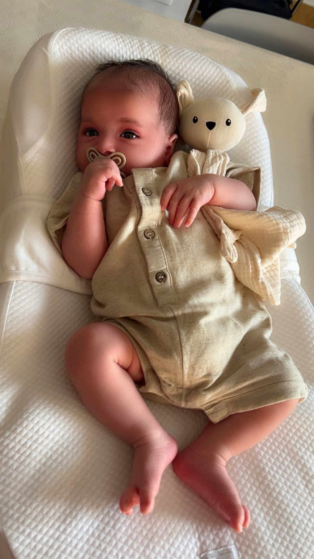 Nils participe au concours pour gagner de l'argent avec cette photo : baby, infant, pacifier, stuffed_animal, romper, cushion, white, beige, sleeping_bed, hand, foot, face, child, indoor, soft_toy, texture, comfort, cute, relaxing, newborn