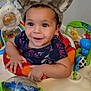 toddler, child, baby, bunny_ears, toy, activity_center, smiling, happy, indoor, playful, colorful, curly_hair, blue_shirt, plastic_toy, floor, carpet, cute, infant, person, expression