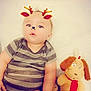 Christopher James is registered to the contest to win money with this photo: baby, candid, child, chubby, cute, dog_toy, face_filter, holiday_theme, indoors, infant, lying_down, onesie, playful, plush_toy, portrait, reindeer_filter, soft_toys, striped_clothing, stuffed_animal, young_child