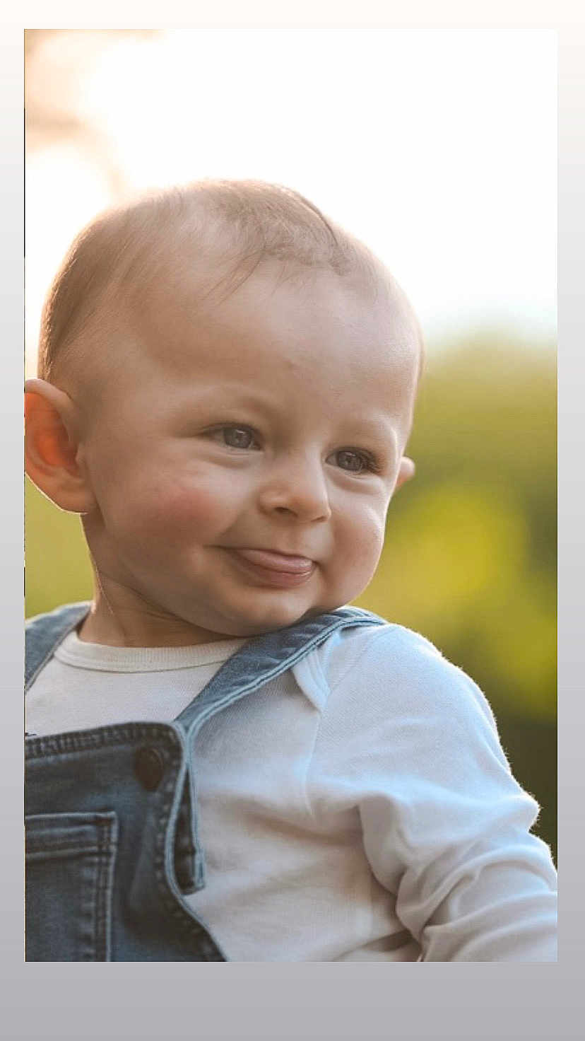 Loën a rejoint le concours — aidez-le/la à gagner de superbes lots ! baby, child, face, smile, tongue_out, denim_overalls, white_shirt, outdoor, natural_light, portrait, head, cheeks, cute, infant, happy, closeup, young, skin, expression, person