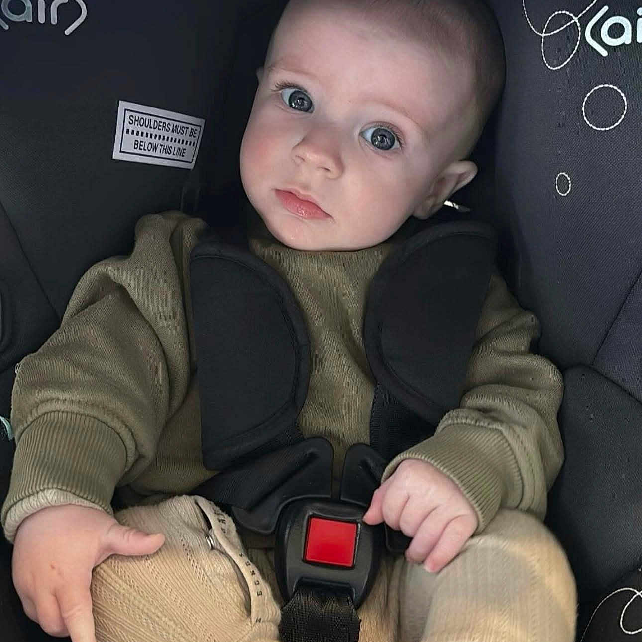 Noah joined the competition — help win amazing prizes! baby, blue_eyes, car_seat, casual_clothing, child, closeup, cute, face, green_sweater, hands, head, indoor, infant, knit_pants, legs, person, safety_harness, seatbelt, serious_expression, young_child