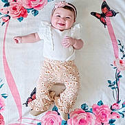 Laluna is registered to the contest to win money with this photo: baby, smiling, infant, floral_blanket, butterfly, white_top, ruffles, peach_pants, patterned_clothing, headband, flower_headband, cute, happy, lying_down, child, small_hands, small_feet, indoors, portrait, soft_lighting